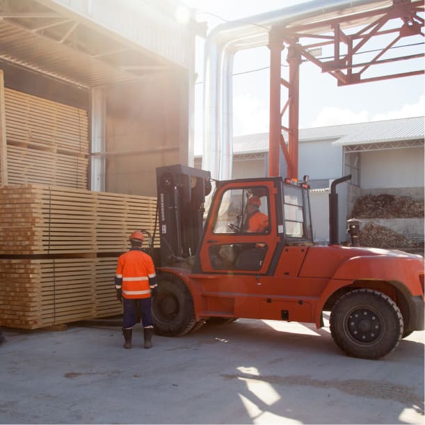 Forklift lifting stacked timber